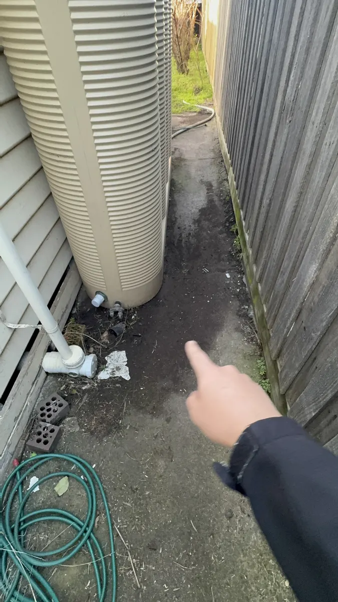 Pooling stormwater against a home, a common cause of soil movement and cracking that drainage repairs solve.